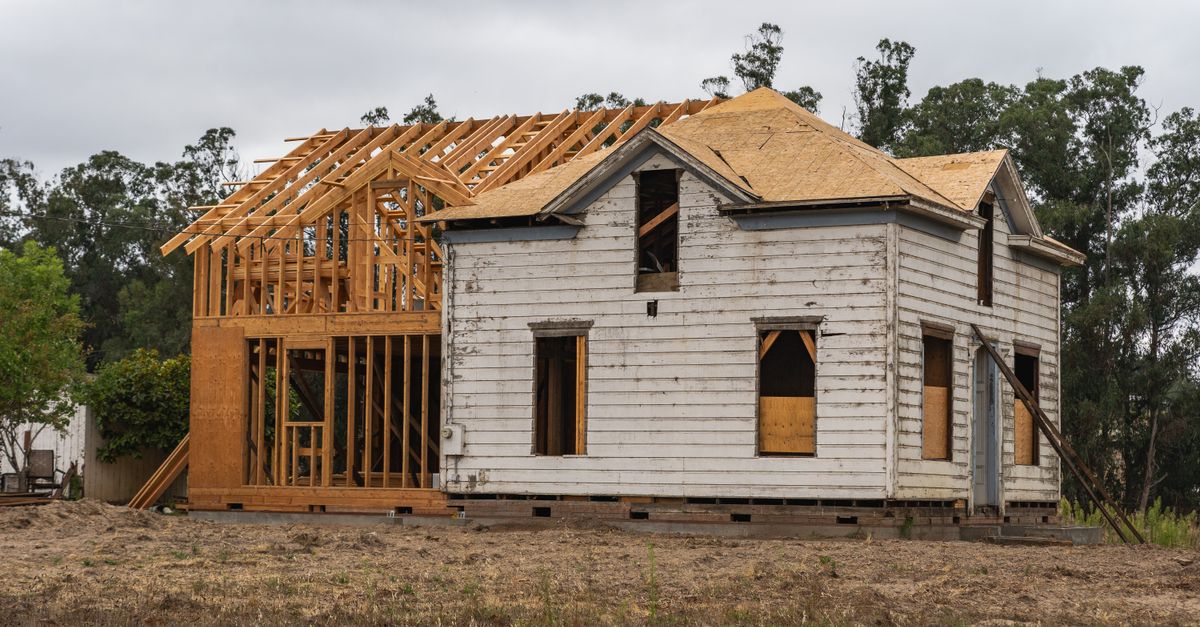 Image of an old house under renovation with new wooden frame structure.